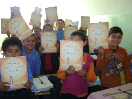 Excited third grade boys in Mazar-I-Sharif receive their own copy of The Boy Without a Name by Idries Shah.